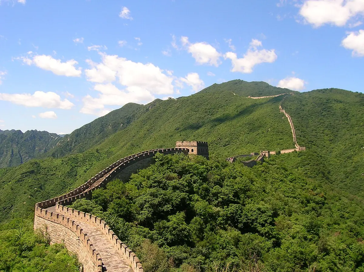 Great Wall watchtowers and battlements following green mountain ridges at Mutianyu